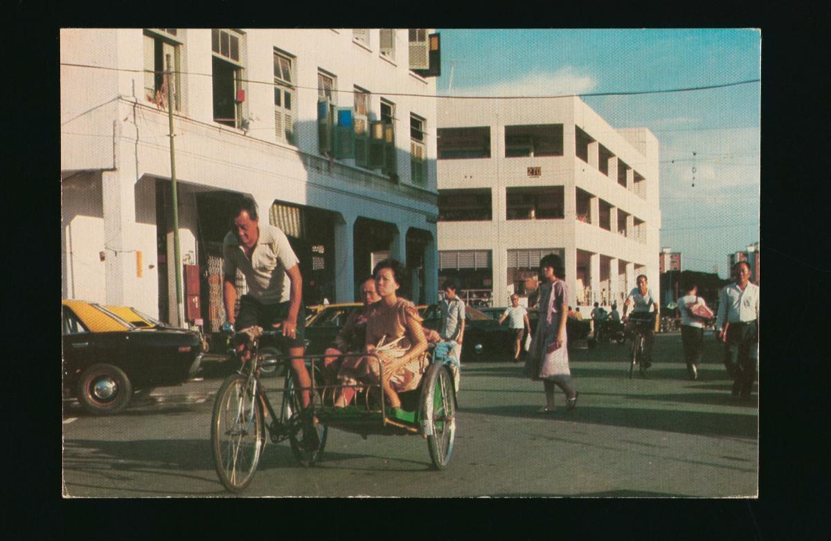 trishaw moving along a busy street
